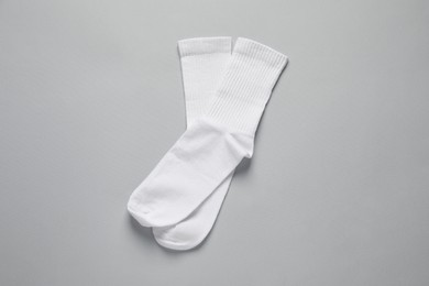 Photo of Pair of white socks on light grey background, flat lay
