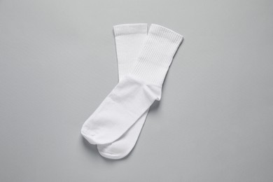 Pair of white socks on light grey background, flat lay