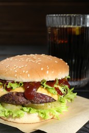 Photo of Burger with delicious patty and soda drink on table, closeup
