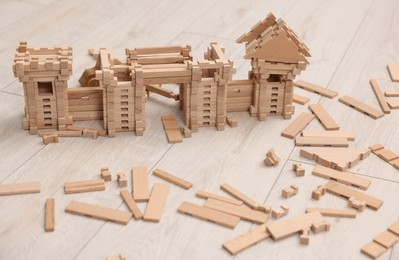 Photo of Wooden construction set on floor indoors. Children's toy