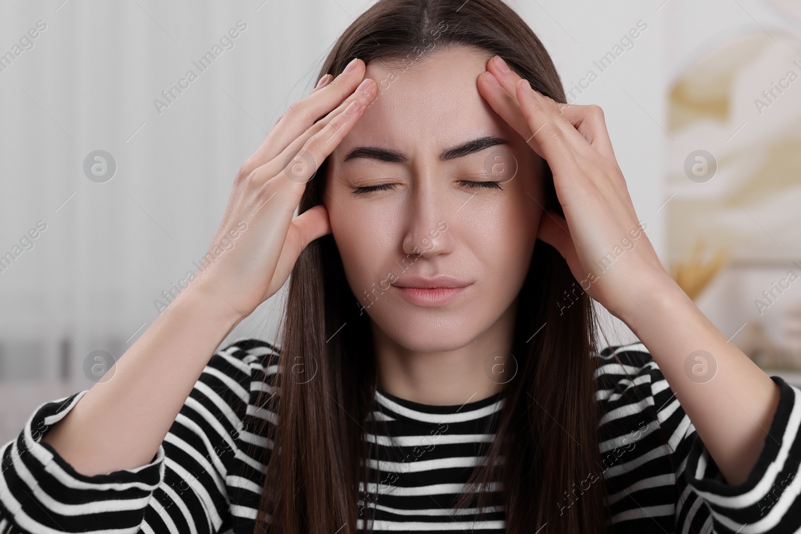 Photo of Sad woman suffering from headache at home