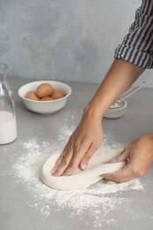 Woman kneading dough for pastry on table