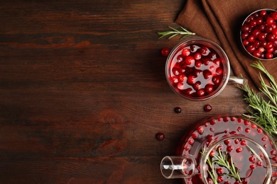 Photo of Tasty hot cranberry tea on wooden table, flat lay. Space for text