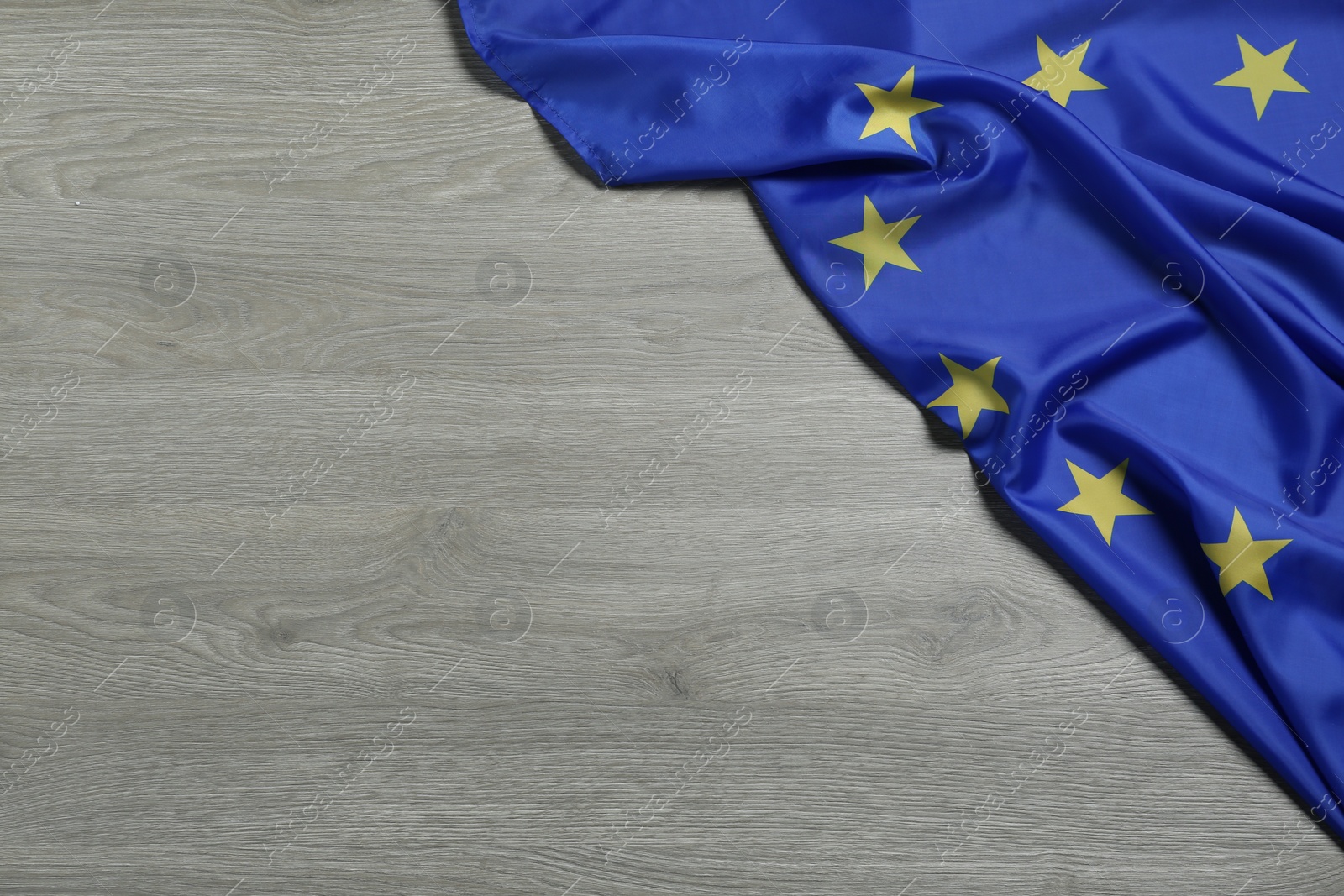 Photo of Flag of European Union on wooden background, top view. Space for text