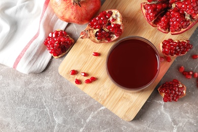 Flat lay composition with pomegranate juice, fruit and seeds on table