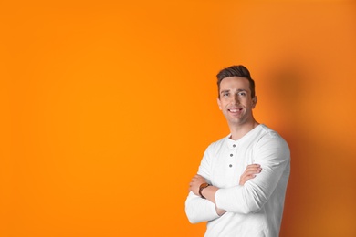 Photo of Handsome young man smiling on color background