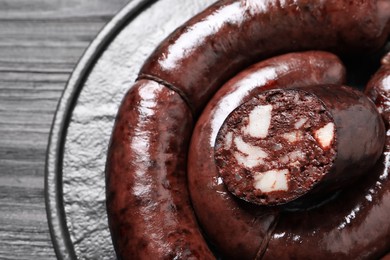 Tasty blood sausages served on black table, top view