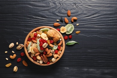 Flat lay composition of different dried fruits and nuts on color wooden background. Space for text