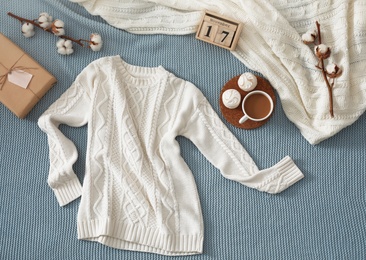 Photo of Flat lay composition with cozy knitted sweater on blanket