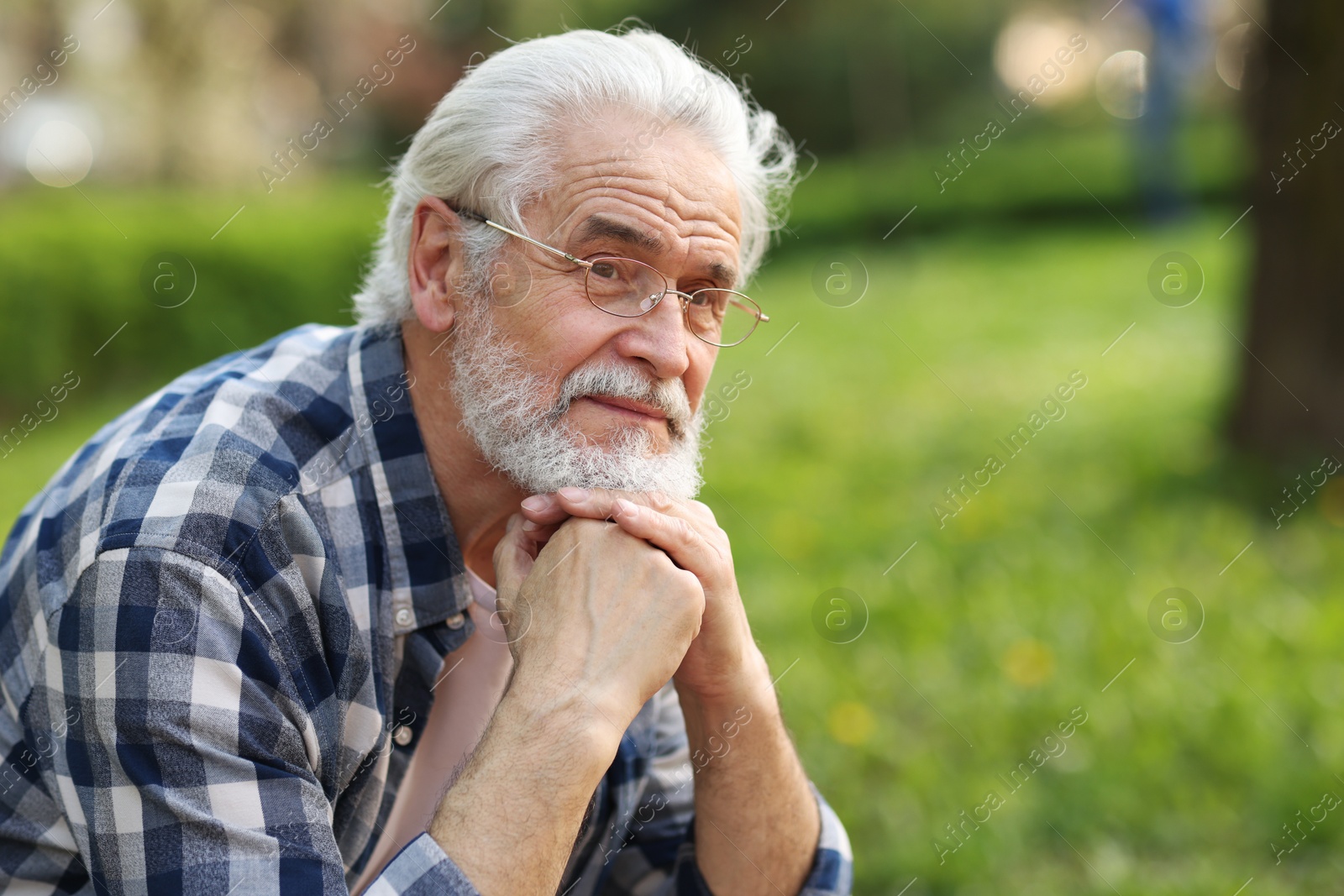 Photo of Portrait of happy grandpa with glasses in park, space for text