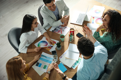 Photo of Team of professional designers working together at table in office