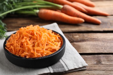 Photo of Grated carrot in plate on wooden table