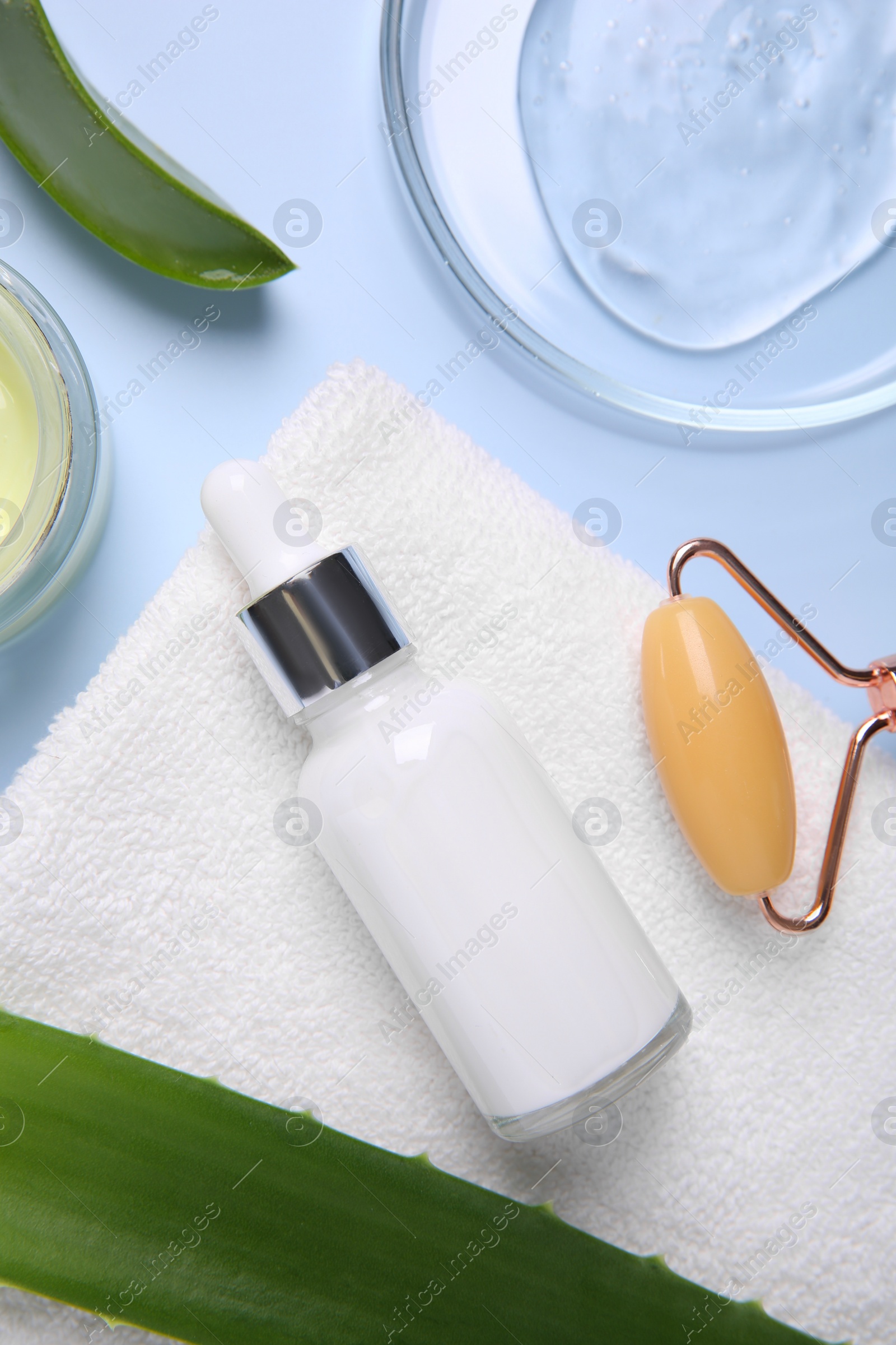 Photo of Flat lay composition with cosmetic products and cut aloe leaves on light blue background