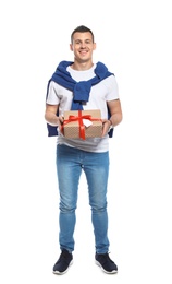 Young man with Christmas gift on white background