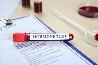 Photo of Hormone test. Sample tube with blood and laboratory forms on table