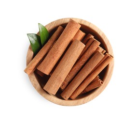 Cinnamon sticks and green leaves in bowl isolated on white, top view