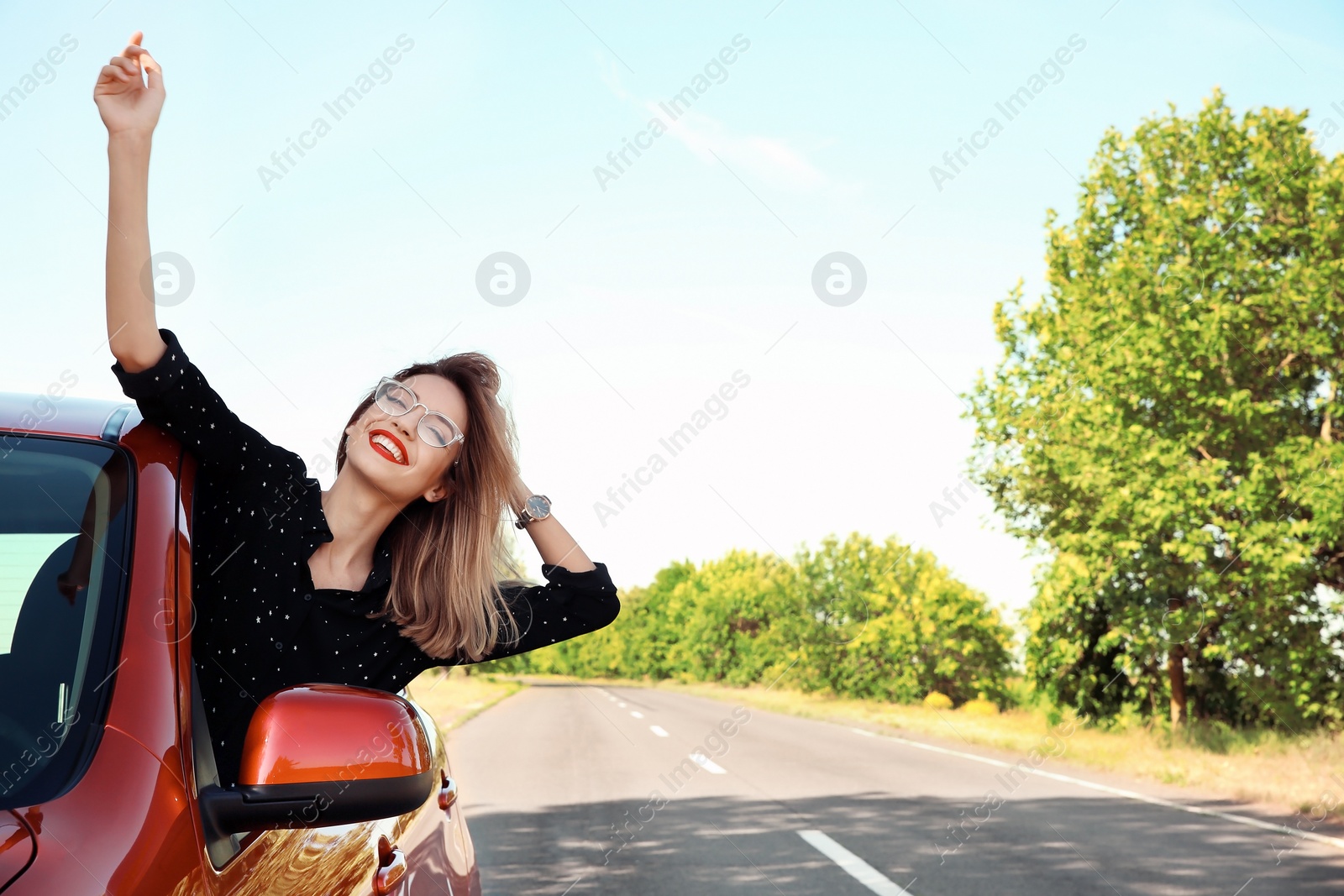 Photo of Young woman leaning out of car window