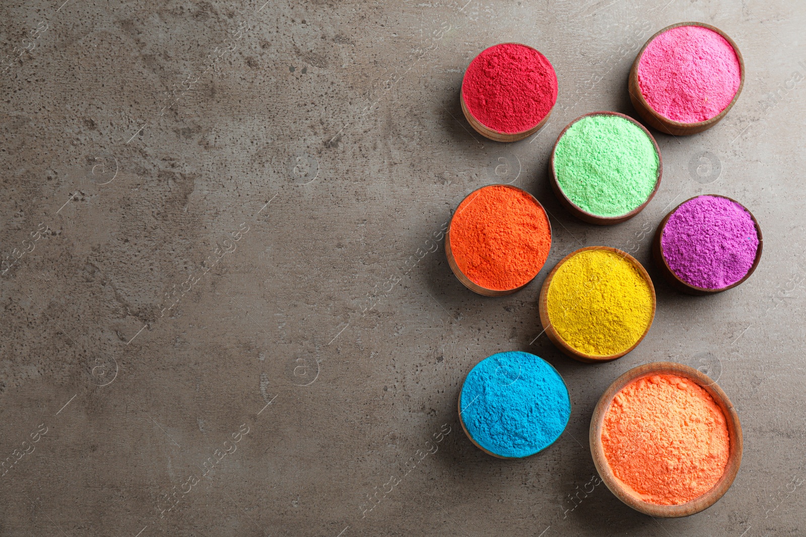 Photo of Colorful powder dyes on grey background, flat lay with space for text. Holi festival