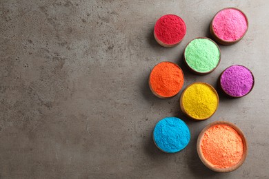 Colorful powder dyes on grey background, flat lay with space for text. Holi festival