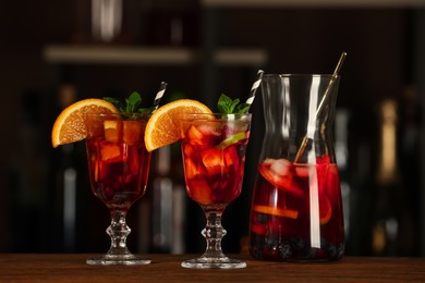 Photo of Delicious sangria cocktail on wooden table in bar