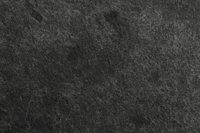 Photo of Texture of dark grey stone surface as background, closeup