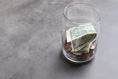 Photo of Donation jar with money on grey background. Space for text