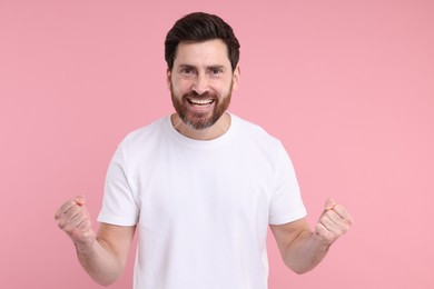 Photo of Portrait of happy surprised man on pink background
