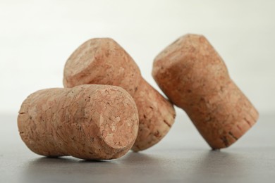 Corks of wine bottles on light grey table, closeup