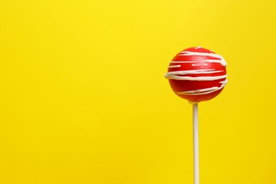 Photo of Bright delicious cake pop on color background. Space for text