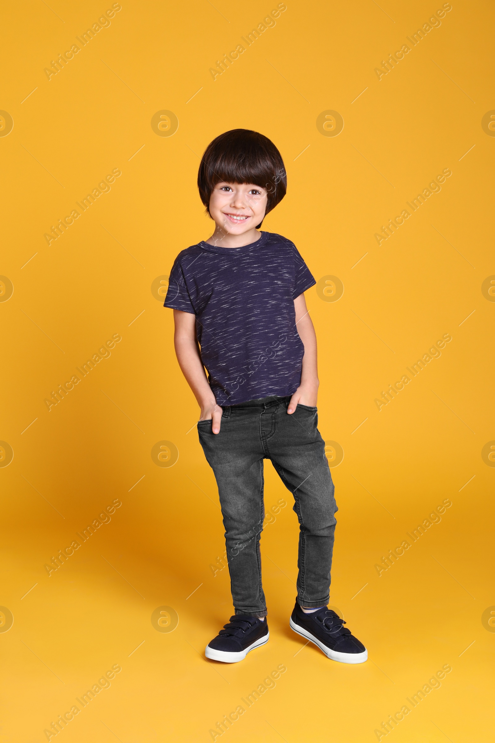 Photo of Full length portrait of cute little boy on yellow background