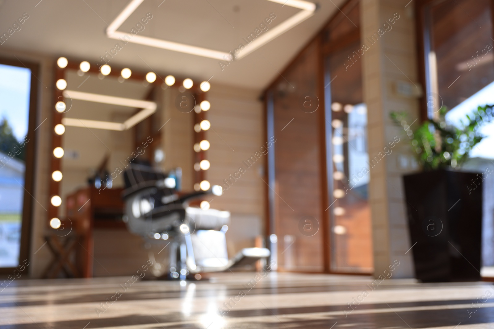 Photo of Blurred view of stylish barbershop interior with hairdresser workplace