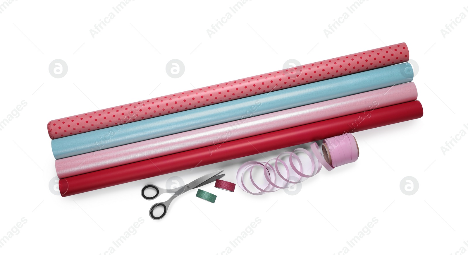 Photo of Rolls of colorful wrapping paper, scissors and ribbons on white background, top view