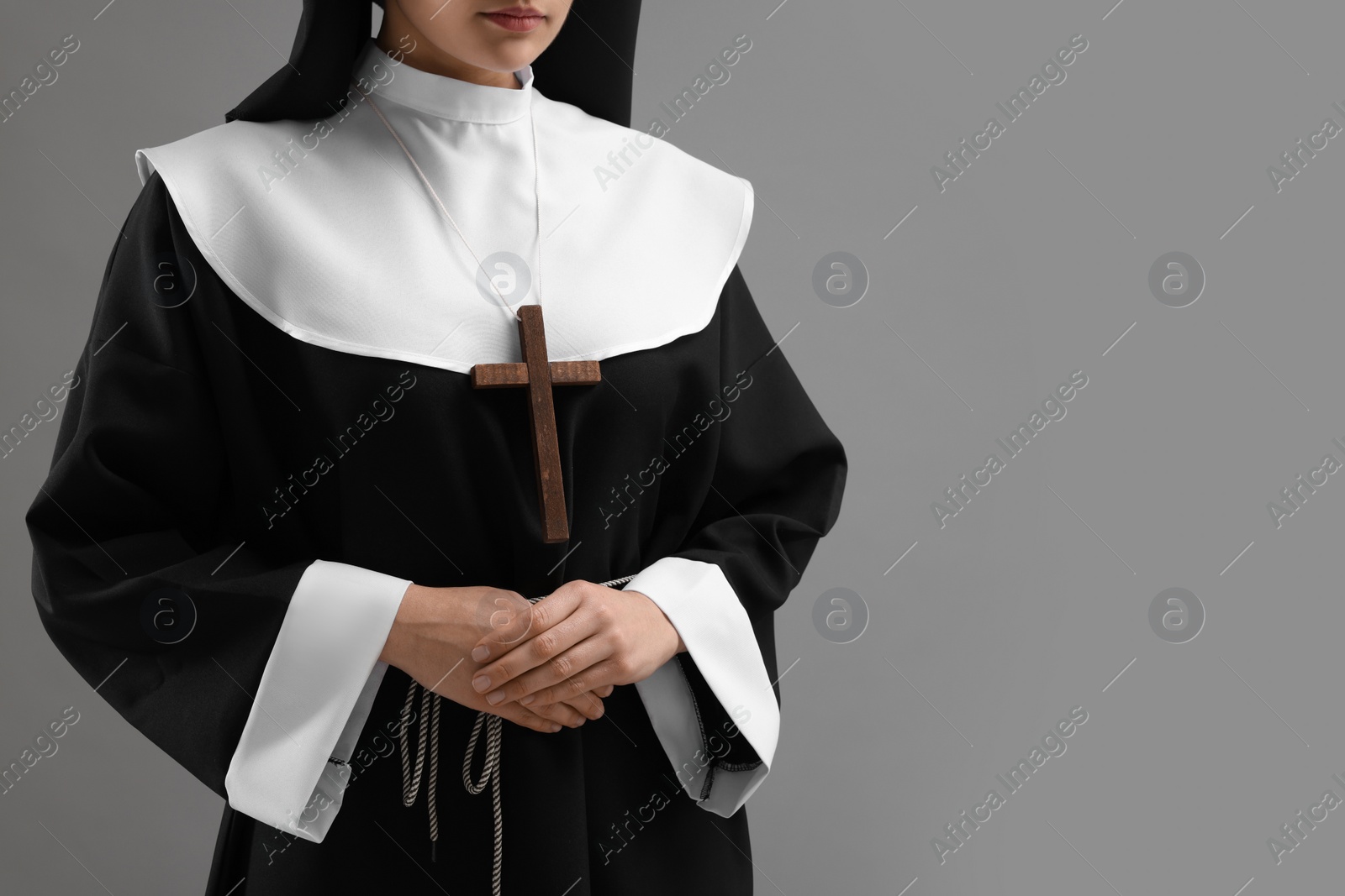 Photo of Nun on grey background, closeup. Space for text