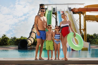 Photo of Happy family with inflatable ring near pool in water park