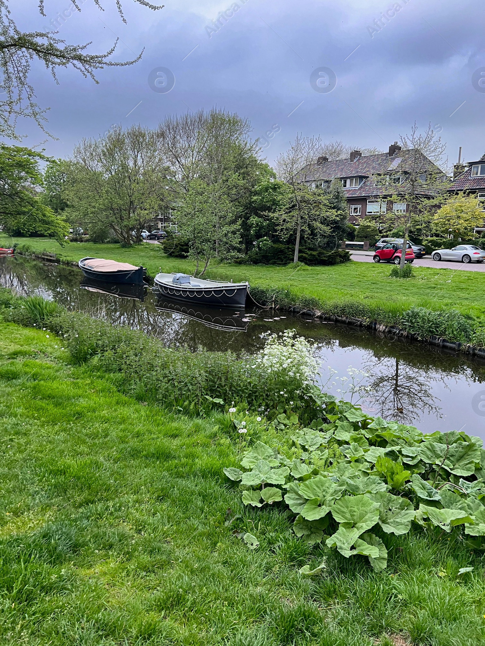 Photo of Canal with moored boats outdoors on cloudy day