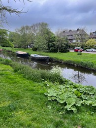 Photo of Canal with moored boats outdoors on cloudy day