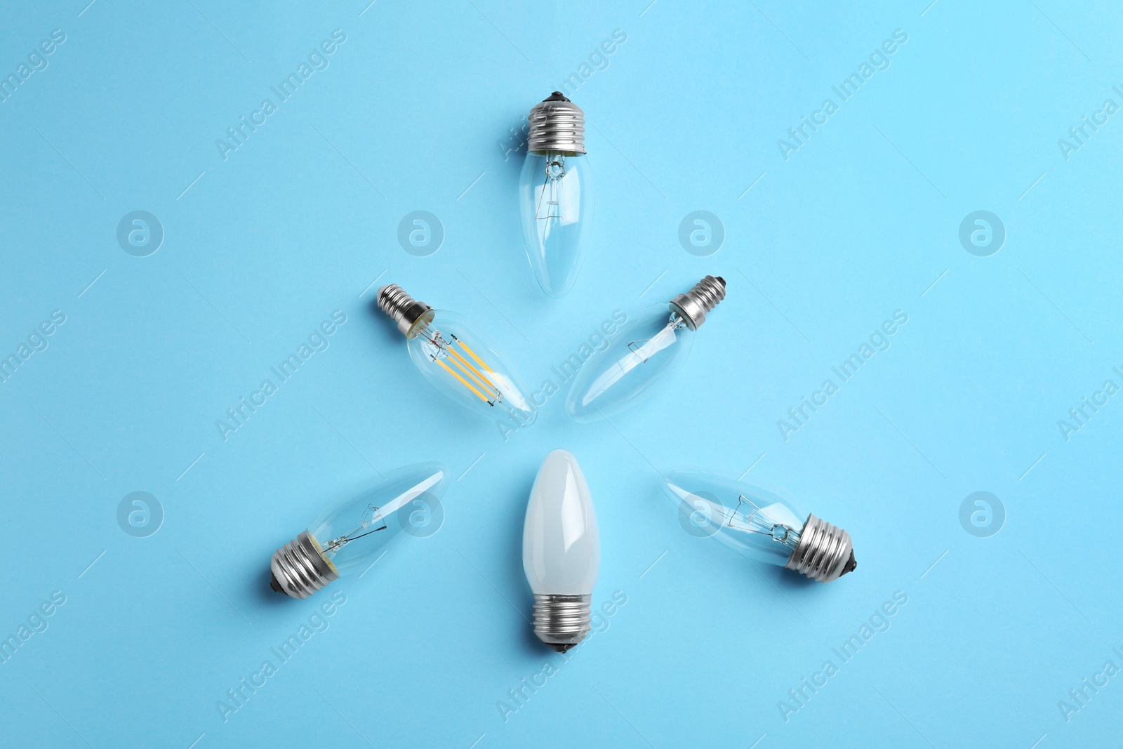 Photo of Different lamp bulbs on light blue background, flat lay