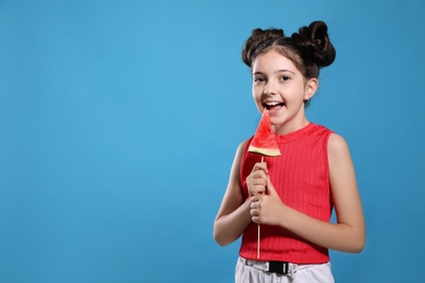 Photo of Cute little girl with watermelon on blue background. Space for text