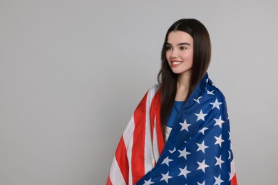 4th of July - Independence Day of USA. Happy girl with American flag on grey background, space for text