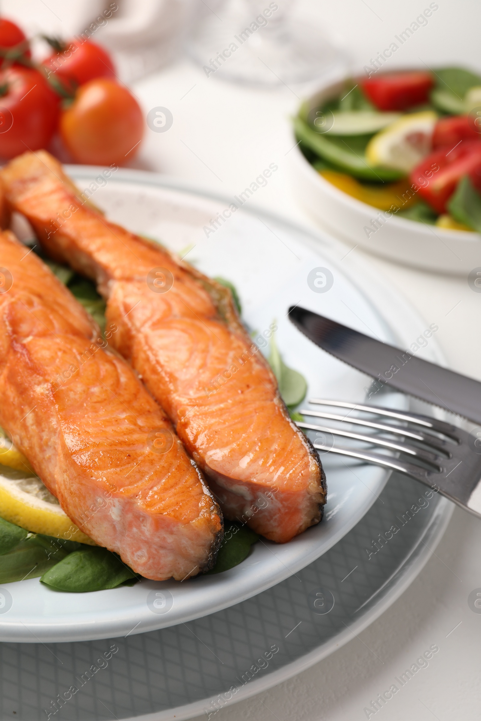 Photo of Healthy meal. Pieces of grilled salmon served on white table, closeup