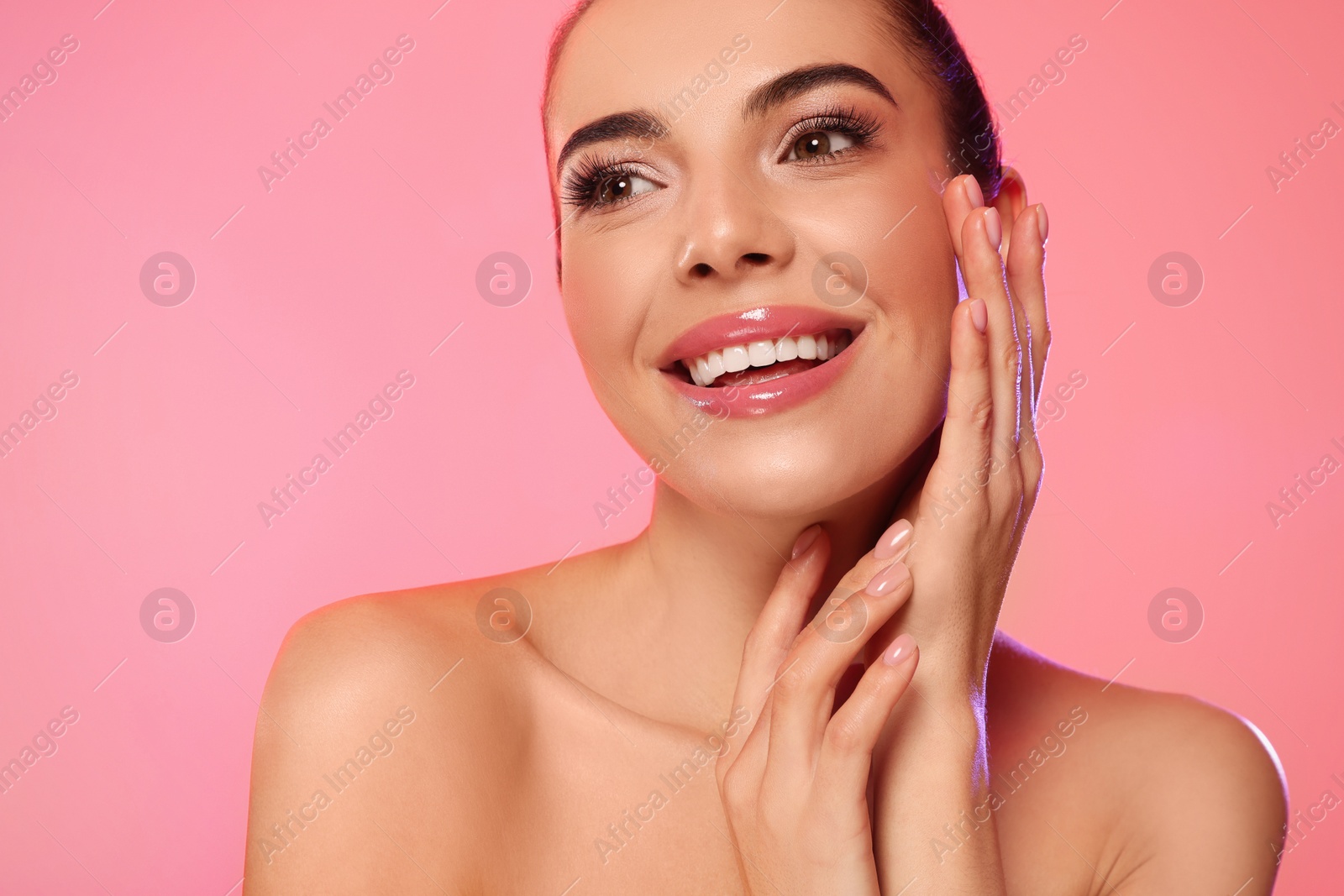 Photo of Portrait of young woman with beautiful makeup on light pink background, closeup