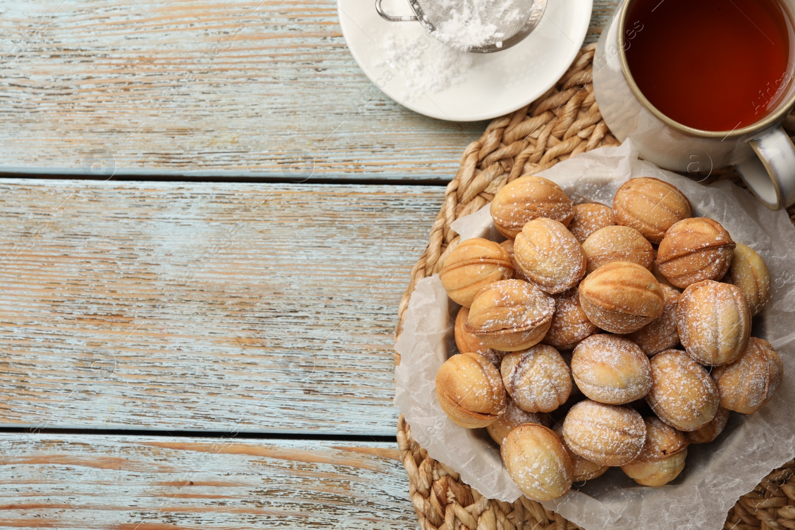 Photo of Bowl of delicious nut shaped cookies on grey wooden table, flat lay. Space for text