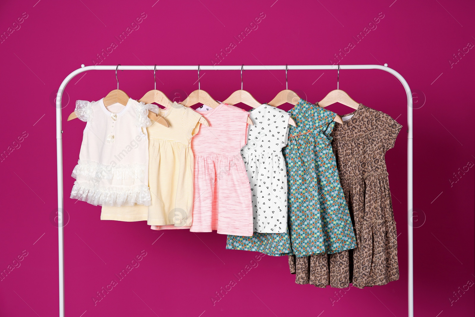 Photo of Rack with stylish child clothes on color background