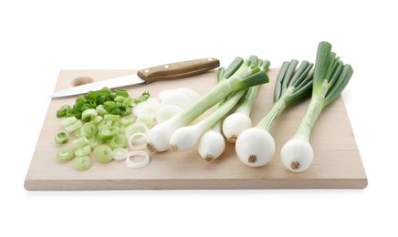 Photo of Wooden board with knife, whole and cut spring onions isolated on white