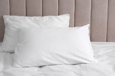 Photo of White soft pillows on comfortable bed indoors
