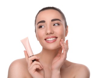 Woman holding tube of foundation on white background