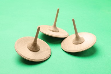 Three wooden spinning tops on aquamarine background
