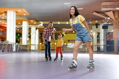Happy family spending time at roller skating rink
