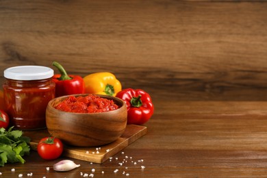 Photo of Delicious lecho and fresh ingredients on wooden table. Space for text