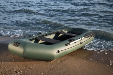 Photo of Inflatable rubber fishing boat on sandy beach near sea